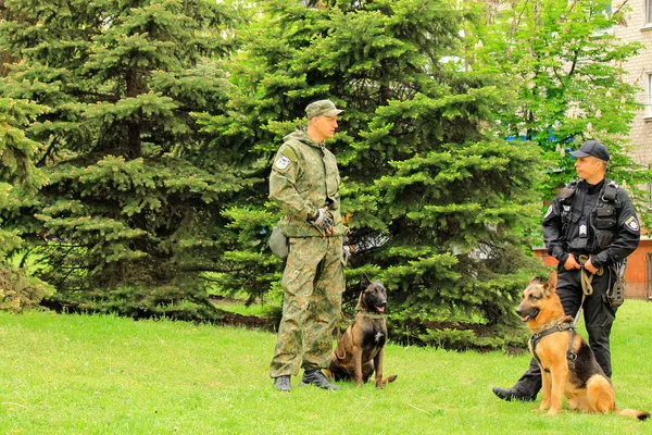 Г. Днепр, Днепропетровск, Украина, 9 мая 2018 года. Украинские полицейские собаководы с дрессированными пастушьими собаками защищают общественный порядок на массовом мероприятии летом — стоковое фото