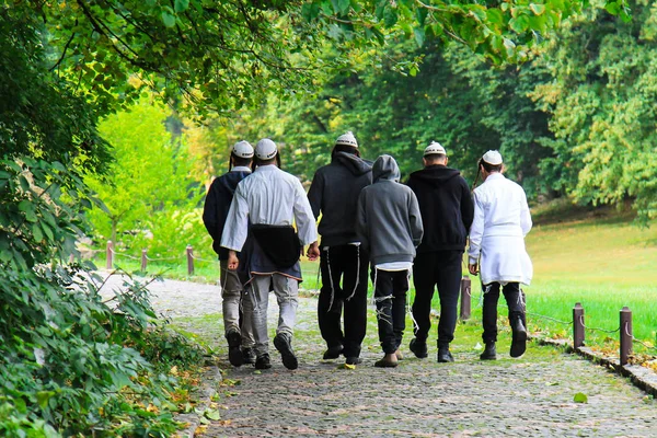 Unga judiska Hasidiska män går i Uman, Ukraina. Religiösa judar. På deras huvuden har de högen, med orden i hebreiska na ingen Nahma Nachman från Uman. Judiska nyåret. — Stockfoto