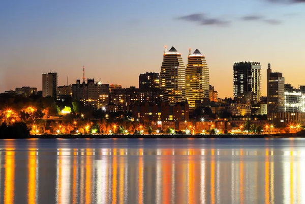 Noche gran ciudad. Hermosos edificios altos, rascacielos y torres en el río por la noche. Dnipro, Dnepropetrovsk, Ucrania, primavera, otoño, verano — Foto de Stock