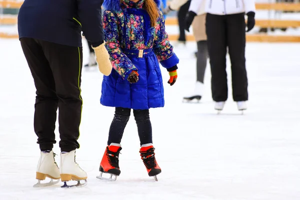 Een meisje in een jasje rijdt met haar moeder op de winter ijsbaan. Actieve familie sporten, winter vakantie voor kinderen, Sport Club — Stockfoto
