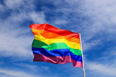 Gökyüzünde sallanan bir LGBT örgütünün gerçekçi gökkuşağı bayrağı. LGBT gurur bayrakları arasında lezbiyenler, geyler, biseksüeller ve transseksüeller yer alıyor.