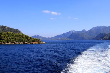 Türkiye 'de Bodrum ve Marmaris yakınlarındaki resim gibi deniz manzarası, suda bir tekneden bir iz, dalgalar, kaynayan bir deniz. Körfezin etrafındaki dağlar ve tepeler, yazlık manzaralar.