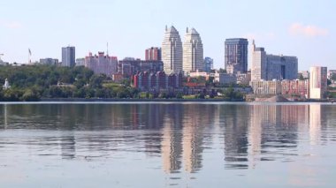 Nehir kıyısındaki büyük şehir. Güzel modern kuleler, binalar, gökdelenler yaz sabahının erken saatlerinde suya yansıyor. Ukrayna 'nın Dnepropetrovsk, Dnipro, Ukrayna