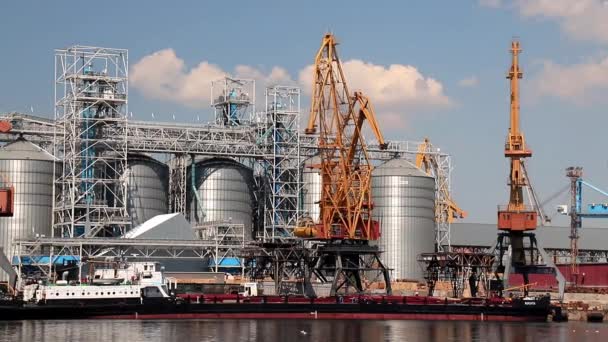 ウクライナのオデッサ2020年7月30日 大きな金属タンクの中にあるオデッサ国際海港には黄色い港クレーンがバージを積み込んでいます 海上の大きな貨物港 船の積み降ろし 商品の保管 — ストック動画