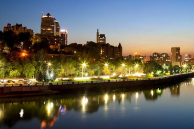Modern binaların, gökdelenlerin, büyük bir şehrin gece kulelerinin güzel bir manzarası. Duvar, akşamları Dinyeper Nehri 'ne yansıyor. Dnipro, Dnepropetrovsk, Ukrayna