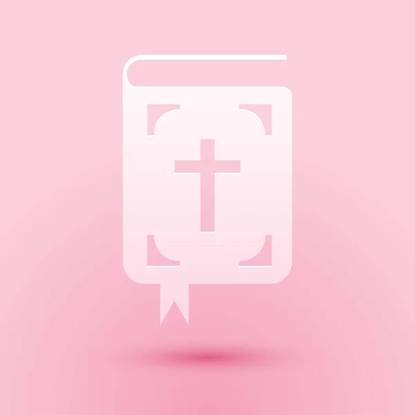 Paper cut Bible book icon isolated on pink background. Holy Bible book sign. Paper art style. Vector — Stock Vector