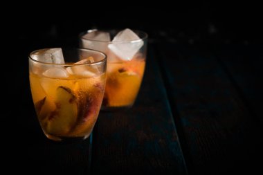 Ahşap masa üzerinde şeftali dilimleri ile şeftali aperol spritz. Yaz kokteylleri. Şeftali soğuk limonata.