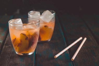 Ahşap masa üzerinde şeftali dilimleri ile şeftali aperol spritz. Yaz kokteylleri. Şeftali soğuk limonata.