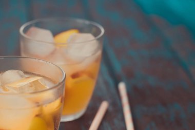 Ahşap masa üzerinde şeftali dilimleri ile şeftali aperol spritz. Yaz kokteylleri. Şeftali soğuk limonata.