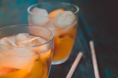 Ahşap masa üzerinde şeftali dilimleri ile şeftali aperol spritz. Yaz kokteylleri. Şeftali soğuk limonata.