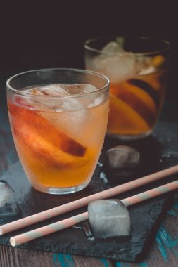 Ahşap masa üzerinde şeftali dilimleri ile şeftali aperol spritz. Yaz kokteylleri. Şeftali soğuk limonata.