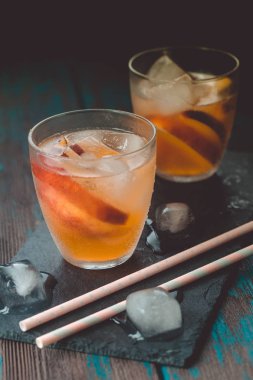 Ahşap masa üzerinde şeftali dilimleri ile şeftali aperol spritz. Yaz kokteylleri. Şeftali soğuk limonata.