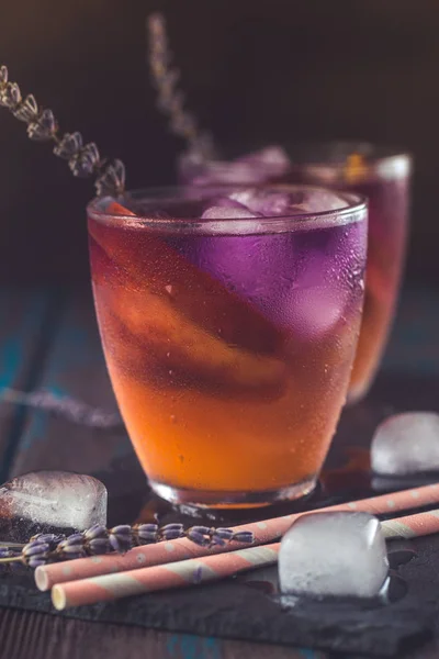 Pfirsich-Aperol-Spritz mit Pfirsichscheiben und Lavendelwasser auf Holztisch. Sommercocktails. — Stockfoto