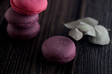 Grup macarons çilek, krema, çikolata ve yaban mersini yaptı. Rustik fotoğraf. Tonda.
