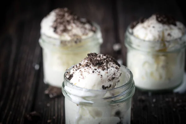Ice cream with chocolate cookies in glass jars. — Stock Photo, Image