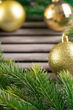 Çam dalları ve ahşap rustik masa üzerinde altın top. Metin için yer. Rustik tarzı Noel.