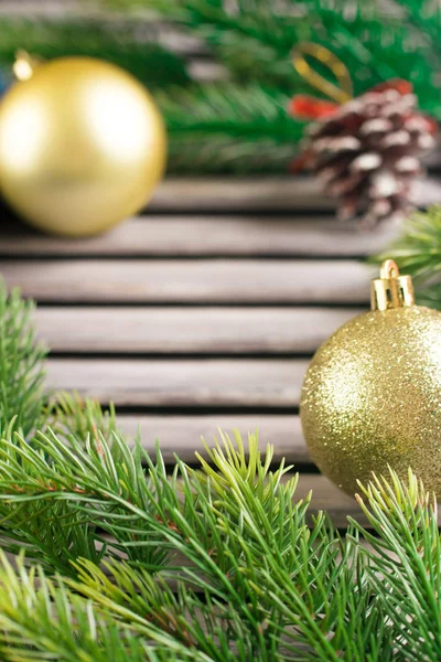 Çam dalları ve ahşap rustik masa üzerinde altın top. Metin için yer. Rustik tarzı Noel.