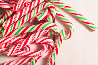 Baston şekerler bir sürü beyaz rustik ahşap masanın üzerinde dağınık.