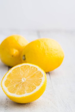 Beyaz ahşap masa üzerinde üç limon. Parlak fotoğraf.