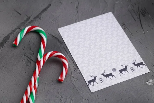 Hard candy canes on grey concrete desk. Christmas decoration.