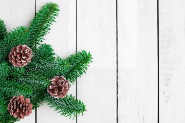 Beyaz ahşap masa üzerinde Noel ağacı dalları.