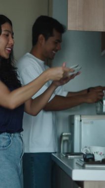 Çift, şık mutfak alanında sabah yemeği hazırlarken işbirliği yapıyor.