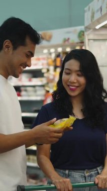 Alışveriş çifti yerel pazar koridorunda ürün seçiyor