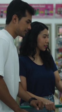 Mağaza koridorunda alışveriş malzemeleri seçen müşteriler