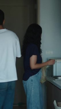 Genç çift, modern mutfaklarında erzak paketlerini boşaltıyor.