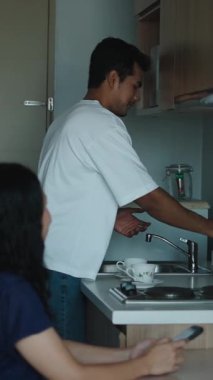 Çift sarılıyor, güneşin doğuşunda mutfak tezgahının yanında hassas bir anı paylaşıyor.