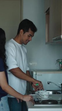 Taze çay demleyen, modern mutfak alanında samimi bir anı paylaşan bir çift.