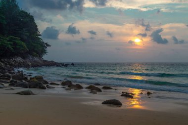 Denizde sakin bir gün batımı. Günbatımı arka planında turkuaz deniz.