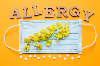 Sarı bir arka plan üzerinde Medikal maske, harfleri dışında beyaz hap ve sarı çiçek, Anti kavramı kelime anti atılır