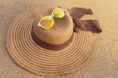 kadın şapka ve güneş gözlüğü ıslak kum, deniz, yaz kavramı üzerinde kahverengi