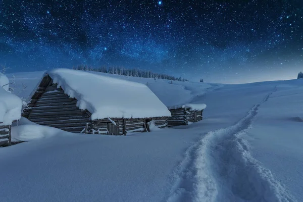 Kışın peri masalı Karpat Dağları gökyüzünde büyüleyici bir samanyolu vadilerde turist çadırları ve karlı evler