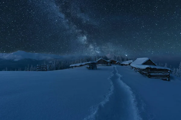Kışın peri masalı Karpat Dağları gökyüzünde büyüleyici bir samanyolu vadilerde turist çadırları ve karlı evler