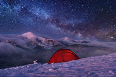 Kışın peri masalı Karpat Dağları gökyüzünde büyüleyici bir samanyolu vadilerde turist çadırları ve karlı evler