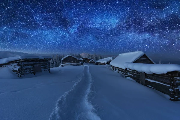 Kışın peri masalı Karpat Dağları gökyüzünde büyüleyici bir samanyolu vadilerde turist çadırları ve karlı evler