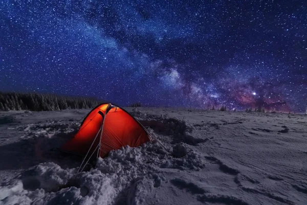 Kışın peri masalı Karpat Dağları gökyüzünde büyüleyici bir samanyolu vadilerde turist çadırları ve karlı evler