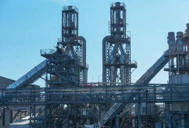 Karmaşık bir endüstriyel binadaki borular, kanalizasyon filtreleri ve diğer metal elementler de dahil olmak üzere çeşitli detaylara ve yüksek kalitede yapısal elementlere sahip bir ahşap fabrikasının resmi..