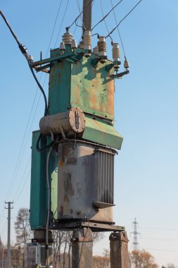 Çeşitli sırıklara ve desteklere sahip elektrik hatları, bir trafo kabininin görünümü.