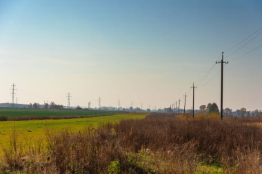 Çeşitli sırıklara ve desteklere sahip elektrik hatları, bir trafo kabininin görünümü.