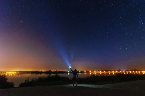Gece gökyüzünde, Samanyolu ve çadırı olan bir turistle birlikte, NEOWISE kuyruklu yıldızı