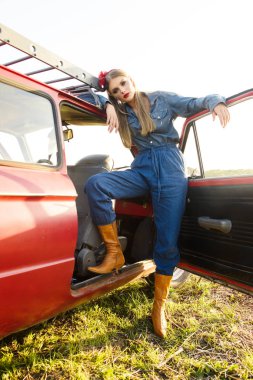 Kırmızı eski arabayla poz kot elbise giymiş kız