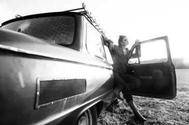 Eski araba ile siyah ve beyaz poz kot elbise giymiş kız