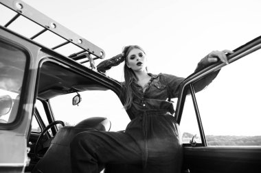 Eski araba ile siyah ve beyaz poz kot elbise giymiş kız