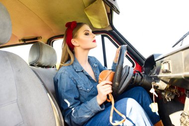 Kırmızı eski araba sürüş denim giysileri giymiş kız