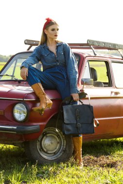 Kırmızı eski arabayla poz kot elbise giymiş kız
