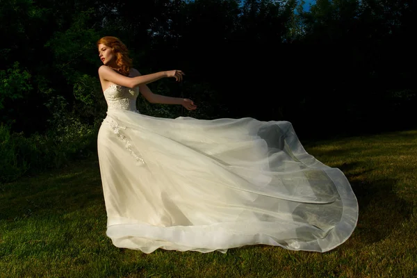 Gorgeous bride in white flying wedding dress