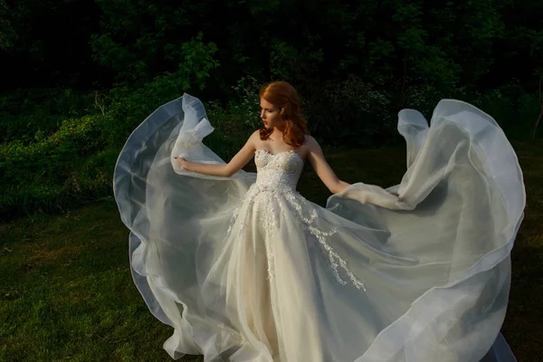 Gorgeous bride in white flying wedding dress